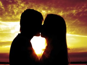 Um casal se beijando no parque ao por do sol